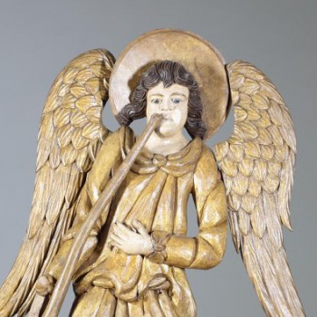 Ангел держит трубу в опущенной правой руке, левая лежит на груди. Фигура изогнута вправо. На фигуре две одежды, собранные в пышные складки. Крылья вырезаны отдельно и вставлены с боков опущенными вниз.