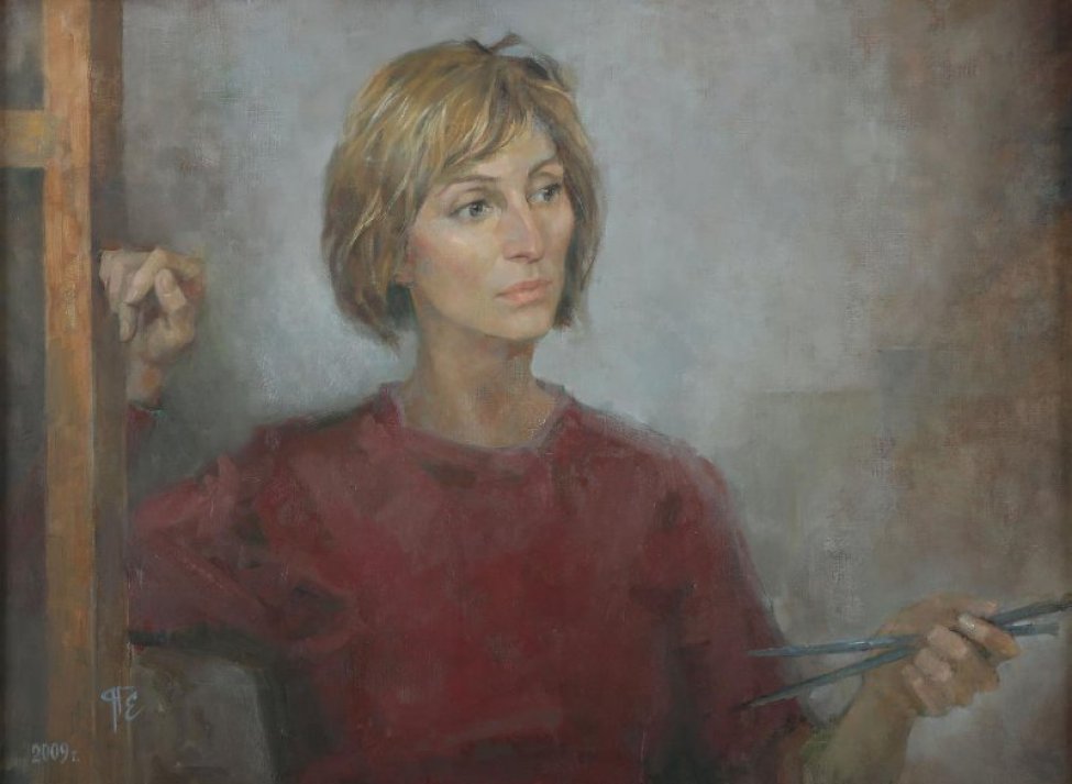 На светло-сером фоне погрудное изображение молодой женщины с короткой стрижкой светло-русых волос, в красной кофточке. Правой рукой опирается на деревянную конструкцию, в левой - две кисти.