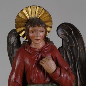 У ангела верхняя одежда окрашена в красный цвет, а нижняя - в синевато-зеленый. Правая рука опущена, а левая - поднята. Сзади находится два отдельно вырезанных крыла.