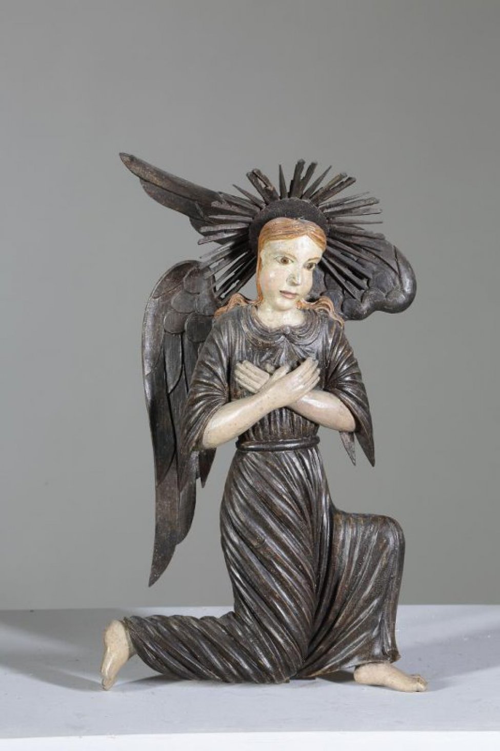 Ангел стоит в верхнем ряду. Изображен со скрещенными на груди руками, в одежде с короткими до локтей рукавами, стоящим по направлению к Саваофу, на правом колене и полусогнутой левой ноге; грудь и голова ангела изображены фронтально; левое крыло имеет взмах вверх.