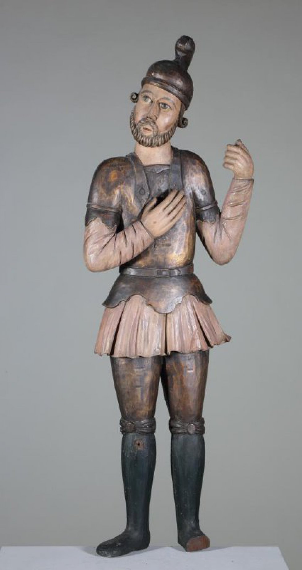 Лонгин Сотник изображен с направленными  вправо лицом. Правая рука лежит на груди; в левой руке, поднятой до плеча находится копье. Воинские одежды позолочены, рубашка окрашена в розовый цвет.