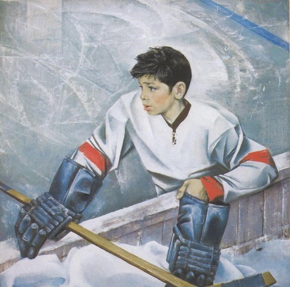 Поясное изображение темноволосого мальчика в профиль в спортивной одежде хоккеиста (светлая куртка с красными полосами, спортивные перчатки), с клюшкой в правой руке.