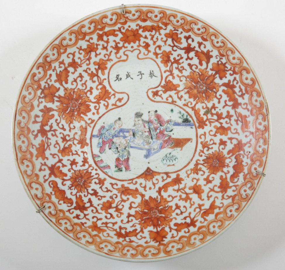 Блюдо круглое, белое; с наружной стороны расписано красным цветочным орнаментом в китайском стиле; на дне (зеркале), в белом фигурном резерве,  жанровая композиция из китайской жизни.