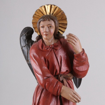 У ангела верхняя одежда окрашена в красный цвет, а нижняя - в синевато-зеленый. Правая рука опущена, а левая - поднята. Сзади находится два отдельно вырезанных крыла.