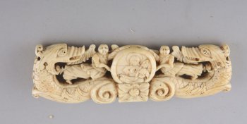 Навершие резное, из моржовой кости, с изображением двух головок грифонов, двух ангелов, летящих между ними, поддерживающих круглый медальон с изображением 