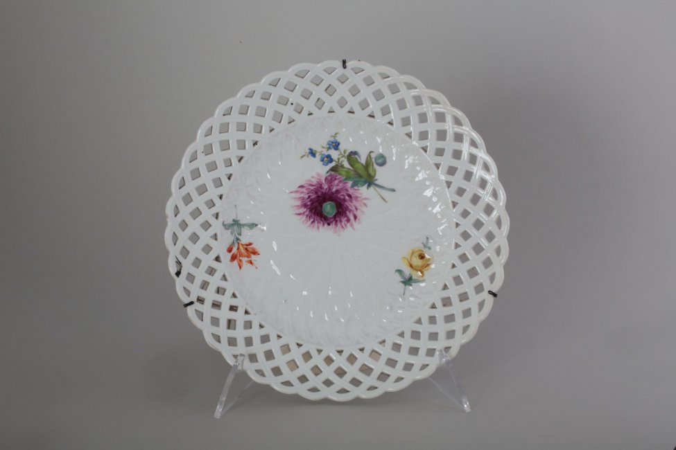 Тарелка мелкая, с волнистым краем; борт  ажурный, ввиде плетенки; На церкале две цветочных ветки и лиловый большой цветок с незабудками