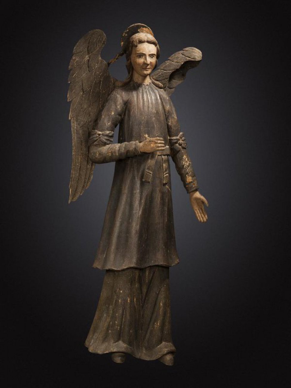 В правой руке ангела - рипида, левая рука опущена. Ангел одет в хитон, поверх которого панцирь, опоясанный поясом. На рукавах выше локтей - бантовые повязки. Сзади на голове - «сияние».
