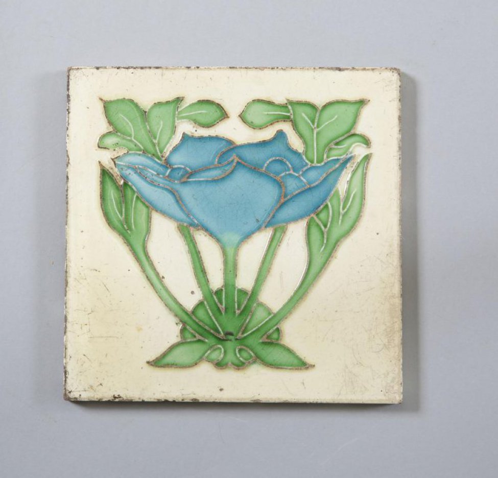 Квадратной формы; на белом фоне - голубой стилизованный цветок лотоса (?) с зелеными листьями и стеблями; контур рисунка выполнен в рельефе; на обороте рельефный штамп в тесте: «MADE IN ENGLAND», «I»