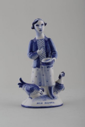 На овально плинте стоит женщина с миской в руках, у ее ног курица и петух; на постаменте надпись: «Моя работа»
