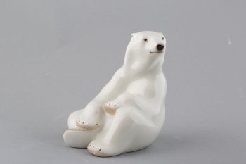 Фигура сидящего белого медведя, края лап - светло-коричневые, с чёрными когтями. Он сидит, согнув правую заднюю лапу; передние лапы сложены. Глова вытянута и повёрнута вправо. Фигура внутри полая.