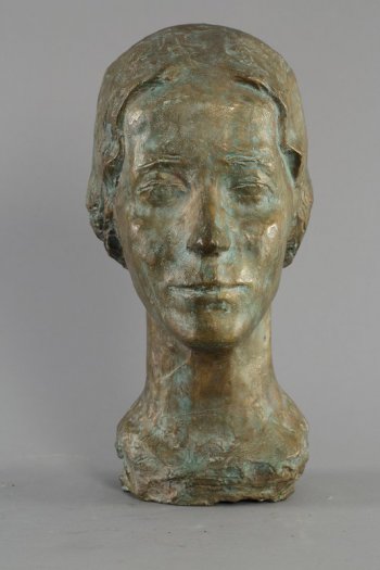 Изображена голова молодой женщины анфас на длинной, тонкой шее. Гладко зачесанные волосы на прямой пробор, закрывая уши, сзади уложены в прическу.