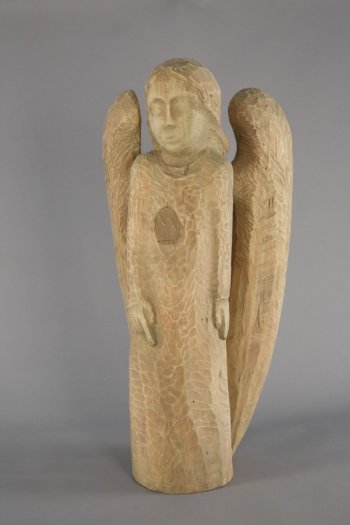 Изображен двукрылый ангел в рост, анфас, руки опущены и плотно прижаты к туловищу (низкий рельеф). Крылья опущены, в нижней части почти сходятся образуя эллипс.