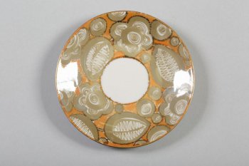 на оранжевом фоне расписаны стилизованные цветы и лисья. В центре блюдца белое кольцо.