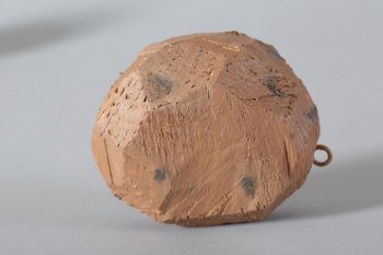 Обобщенное изображение картофелины округлой формы, коричневого цвета, с черными пятнами, с круглым металлическим креплением.