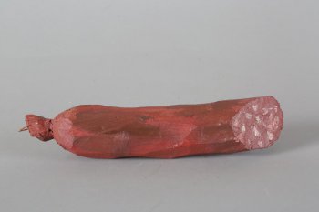 Обобщенное изображение части палки копченой колбасы в оболочке темно-красного, с темными коричневыми пятнами, цвета. С одной стороны - 