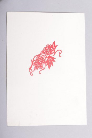 Вырезка из красной бумаги, наклеенная на белую. Вырезаны две кисти ягод  с двумя листьями и усиками по сторонам.