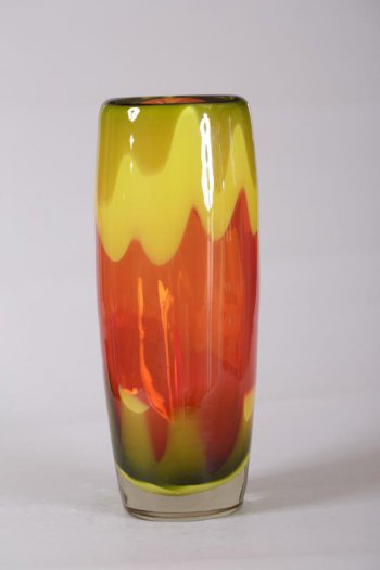 Ваза высокая, цилиндрической формы, суживающейся кверху и основанию. Верхняя и нижняя части вазы  зелено-желтого цвета, центральная - красная. Горловина вогнута внутрь тулова.