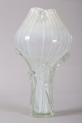 ваза круглой формы на высокой тонкой ножке с прозрачными листьями-налепами, с открытым верхом; опаловое стекло голубоватого цвета с вертикальными молочного цвета полосами.