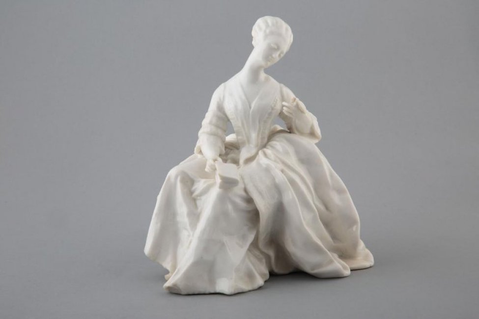 изображена сидящая женщина в длинном платье (18 век). Голова склонена к левому плечу, рука согнута в локте. Правой рукой женщина придерживает книгу, лежащую на коленях.