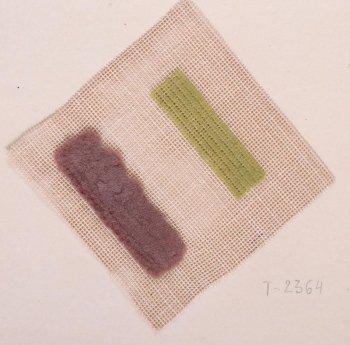 На квадратном кусочке твёрдой плотной канвы бежевого цвета даны два образца вышивки. Первый образец в виде узкой полоски светло-зелёного цвета из тонких рядов. Второй образец: полоска высокого светло-коричневого ворса, созданная тремя рядами шитья.