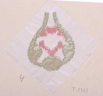 На белом шёлке квадратной формы в технике аппликации вышита светло-зелёная фигура в виде бутона. Внутри неё - аппликация из розового шёлка. Ткани аппликации обшиты зелёными и розовыми шёлковыми нитями. Образец приклеен к картонному листу.