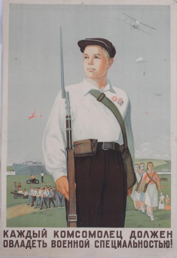Изображен стоящий с винтовкой и с противогазом юноша. На втором плане молодежь, готовая к санитарной и химической обороне.
