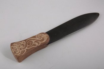 Лезвие ножа параболической формы черного цвета. Рукоятка ножа выполнена из каленого талькохлорита и украшена резьбой на тему звериного стиля.