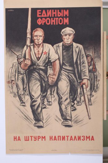 Изображены двое рабочих, идущих рука об руку. У одного в руке винтовка и растегнутая рубашка с красной звездой. Второй в шапке и пиджаке держит рукой отбойный молоток. На втором плане идущие рядами рабочие.