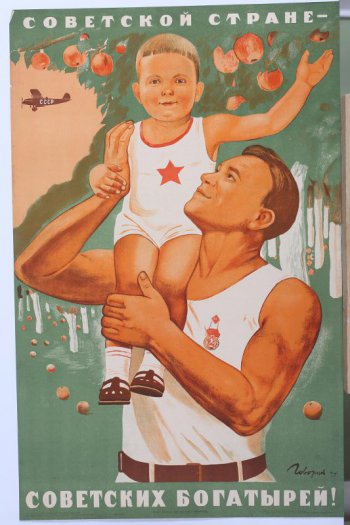 Изображен здоровый молодой мужчина в белой майке. На плече держит здорового красивого ребенка тоже в майке со звездой на груди.