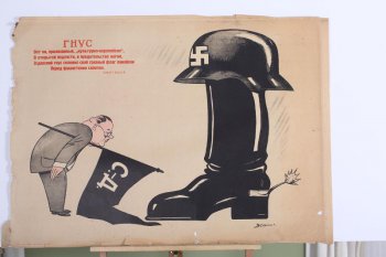 Изображен фашистский сапог со шлемом. Слева согнутая фигура социал.демократа, с черным флагом с надписью С.Д. под мышкой.Вверху слева текст: Вот он... сапогом ( Демьян Бедный).