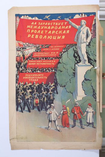 Изображен справа Ленин на пьедестале с вытянутой вперед рукой. Слева на улице толпа демонстрантов со знаменами- на которых лозунги: 