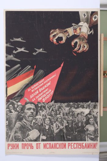 Изображены вверху справа фашист с огромными коготистыми руками. Внизу толпа манифестантов с Знаменем и лозунгом 