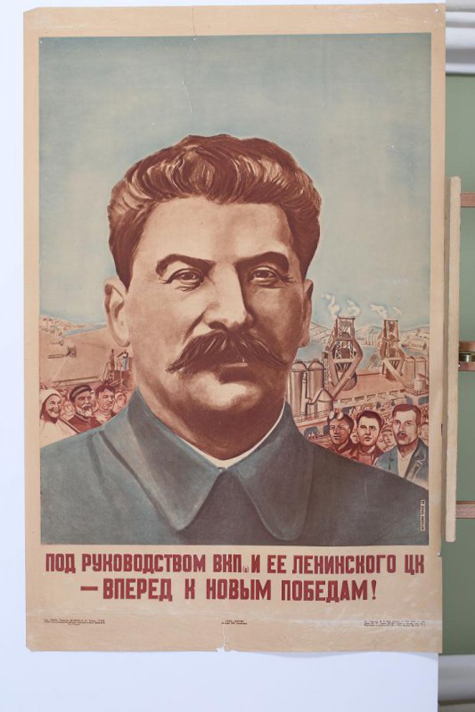 Изображен портрет т.Сталина погрудный. На втором плане индустриальные постройки,крестьяне и рабочие.