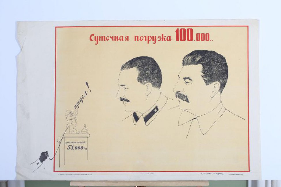 Изображены в середине портреты т.Сталина и т.Кагановича. Внизу слева на трибуне карликовая фигура оператора,указывающая на слово" Предел!". На кафедре надпись: Суточная погрузка 53000,ваг.