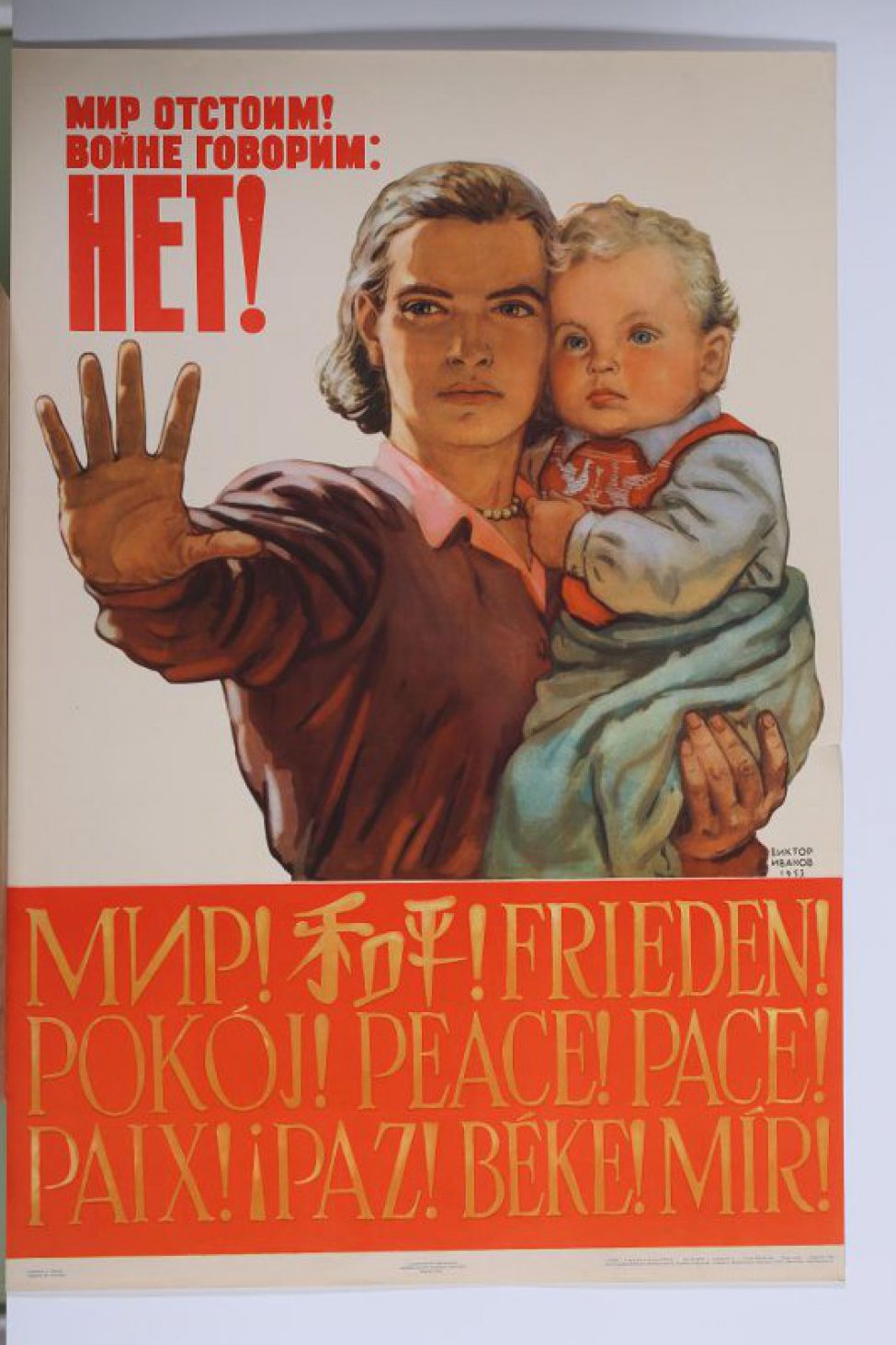 Изображена молодая женщина с ребенком на одной руке. Другая ее рука  протянута вперед.Внизу на красном слове на разных языках слово"мир".