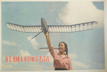 Изображена девушка в розовой блузке, с моделью самолета в поднятой вверх руке. Слева 12 иероглифов.