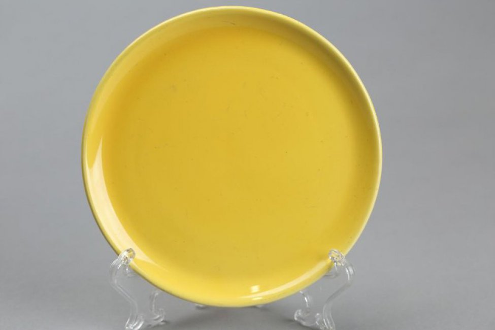 Тарелочка-подставка круглая, плоская, с невысоким бортом. Тарелочка покрыта сплошь желтой глазурью.