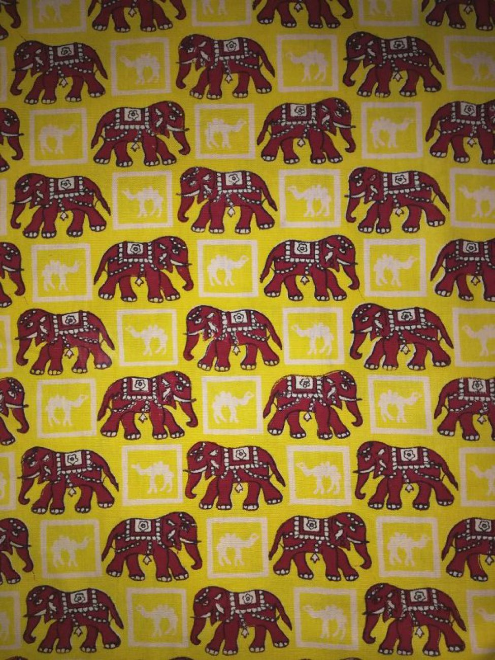 Желтого цвета с набивными красными слонами и белыми верблюдами в белых клетках, расположенными в шахматном порядке.
