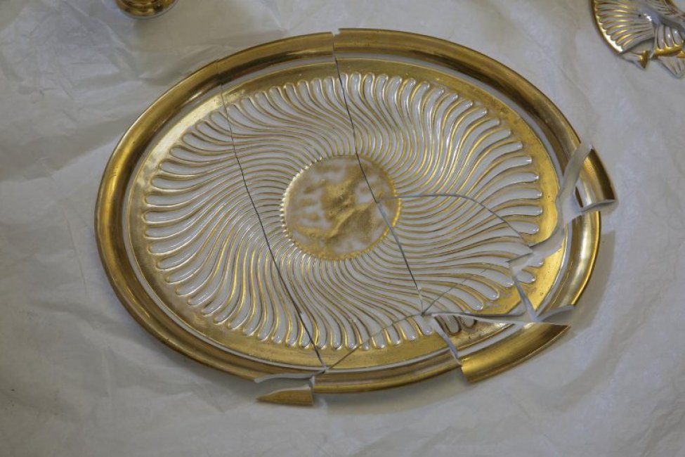 Элипсообразной формы, в стиле ампир, золоченое, с контррельефом; на зеркале - золоченый медальон.