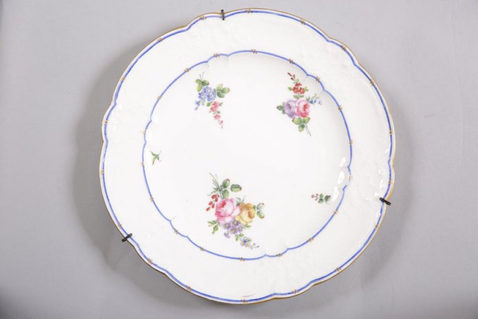 Тарелка мелкая, белая, с синими волнистыми каемками по борту; на зеркале - букеты цветов