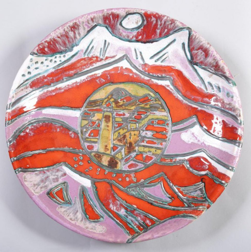 В центре в круге изображен горный поселок с минаретом на переднем плане. По краям  блюда изображен горный стилизованный пейзаж красного, сиреневого, бело-розового цветов.