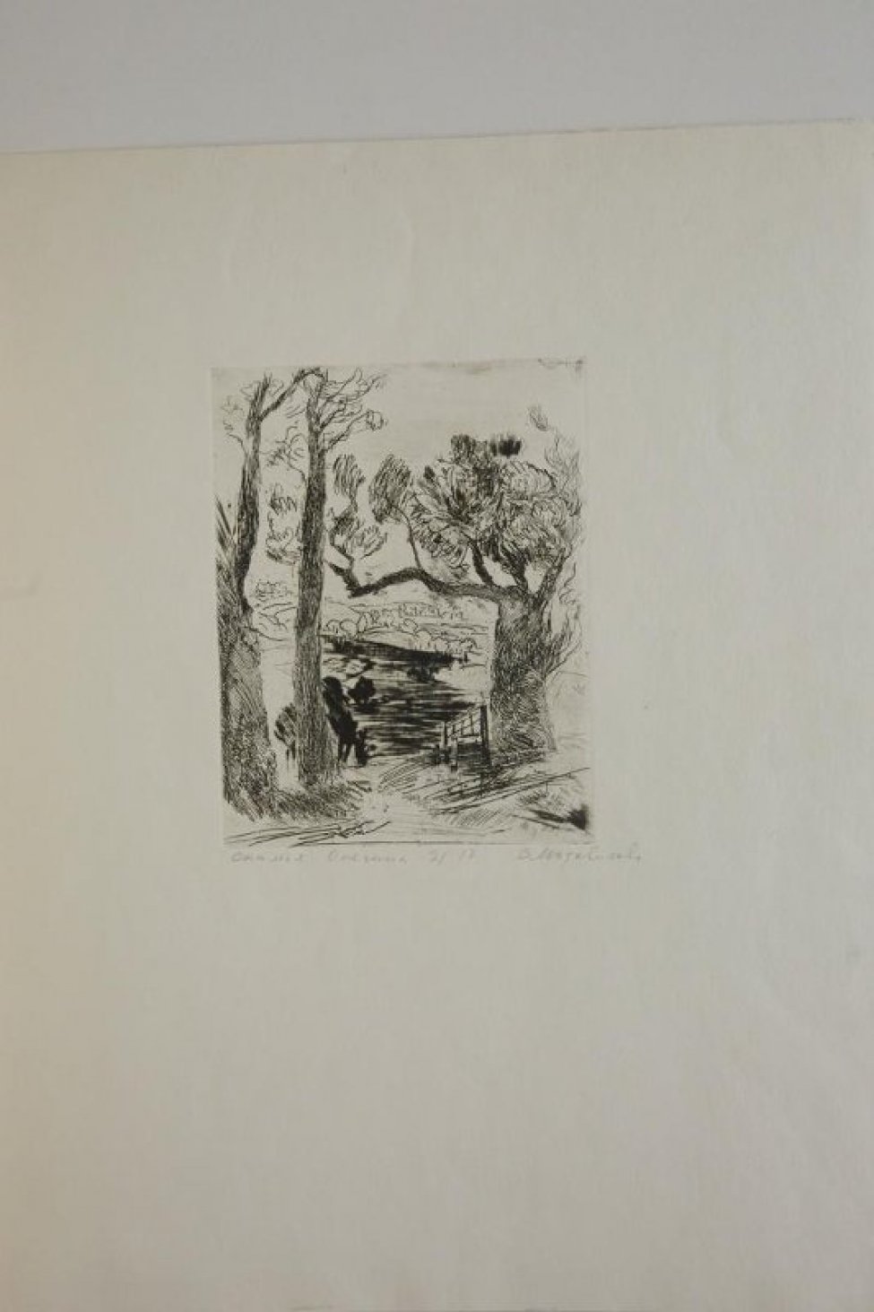Изображен пейзаж с рекой. На первом плане слева - стволы двух деревьев, справа - дерево с раскидистой кроной, под деревом скамья.