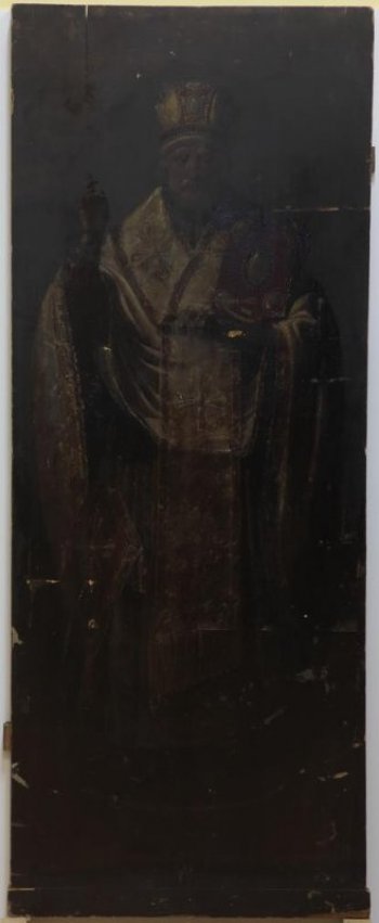 Доска: Икона без выемки, с двумя врезными шпонками.
Изображен святой в рост, в епископском облачении, с митрой на голове, с евангелием в руке.