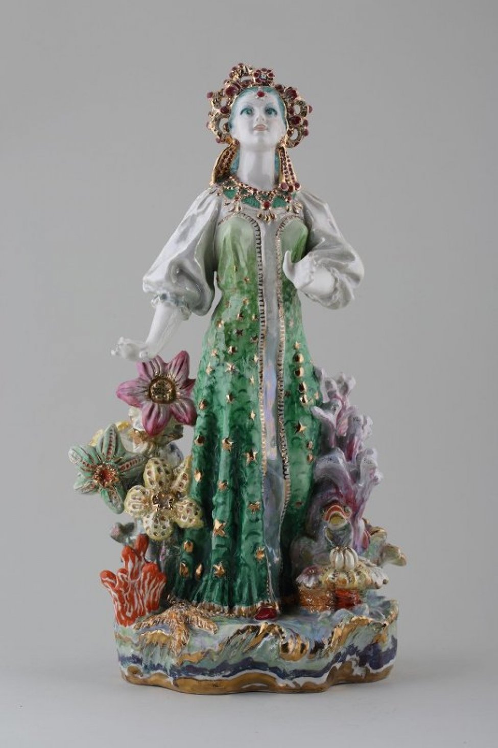 Фигура молодой девушки на плинте, идущей по «морю», среди стилизованных цветов; она одета в национальный русский сарафан малахитового цвета, на голове стилизованный кокошник;